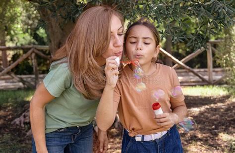 Mother And Daughter Blowing Soap Bubbles In A Park Stock Image Image