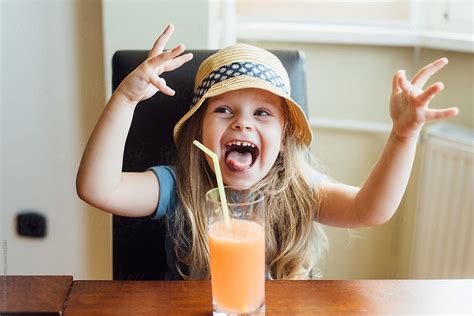 Cheerful Young Girl Drinking Juice By Stocksy Contributor Boris Jovanovic Stocksy