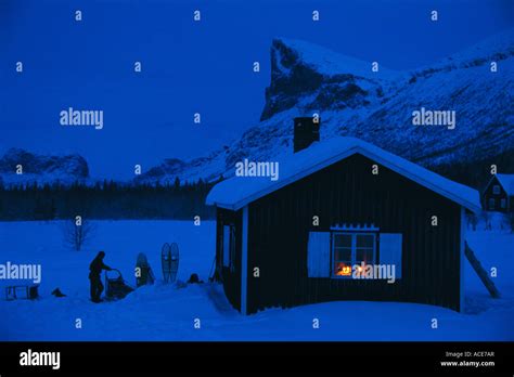 A Mountain Cabin With Lights On In The Window Stock Photo Alamy