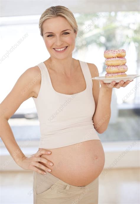 Pregnant Woman With Doughnuts Stock Image F005 6047 Science Photo Library