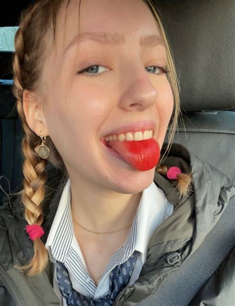 A Woman With Braids Sticking Her Tongue Out In The Back Seat Of A Car