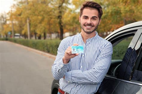 Young Man Holding Driving License Near Open Car Stock Photo Image Of