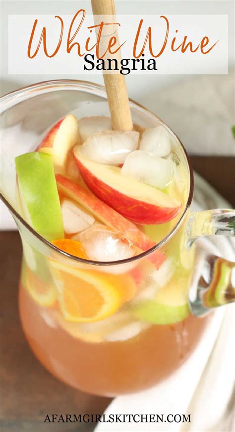 Glass Pouring Pitcher Of White Sangria With Orange Slices Ice Cubes