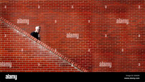 Man Walking Down Stairs With Brick Wall In Background Stock Photo Alamy