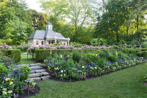 A Lush Backyard Garden Features Tiered Flower Filled Garden Beds And A