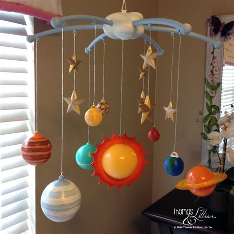 A Mobile With Planets Hanging From It S Sides In Front Of A Windowsill