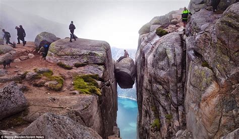 Daredevil Tourists Pose On Kjeragbolten Boulder Wedged In Mountain