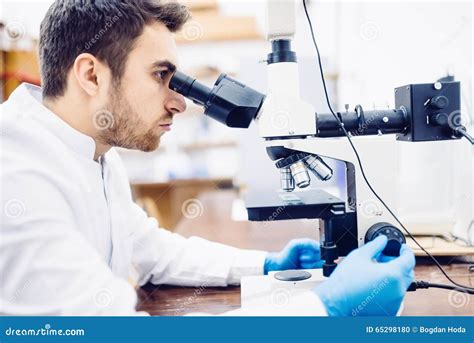 Male Scientist Chemist Working With Microscope In Pharmaceutical