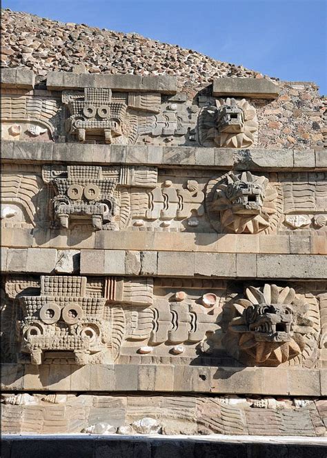 An Intricately Carved Stone Wall With Faces On It