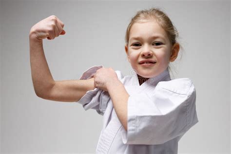 Portrait Of A Little Girl Showing Biceps Muscle And Endurance Training
