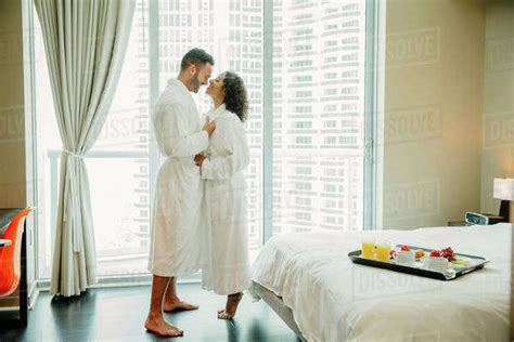 Couple Hugging In Bathrobes In Hotel Room Stock Photo Dissolve