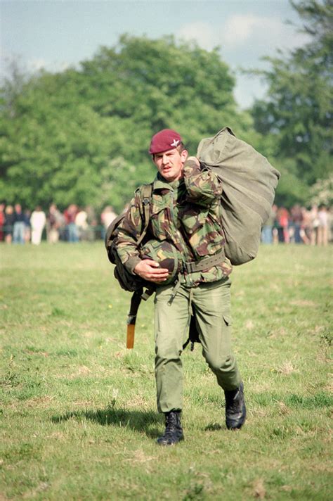 A British Paratrooper Carries His Gear Off The Landing Zone After A Re