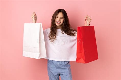 Satisfied Little Girl Holding Shopping Paper Bags Excited With Mall