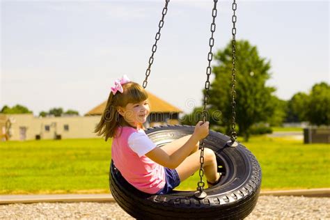 Child Swinging On A Tire Swing At The Park Stock Photo Image Of