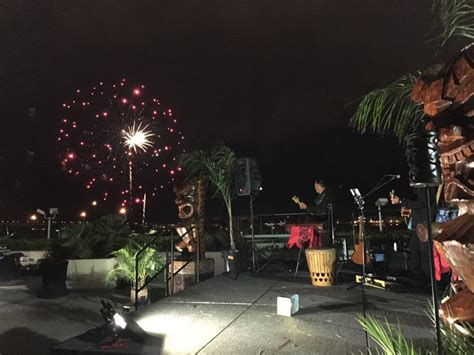 Fireworks Go Off Over The Ocean Behind The Islanders Luau Band At The
