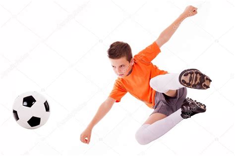 Niño con traje de fútbol y camisa jugando al fútbol aislado en blanco Foto de stock