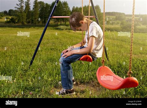 Sad Lonely Boy Sitting On Swing Alone Stock Photo Alamy