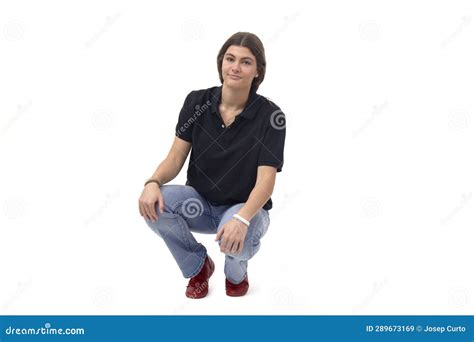 Front View Of A Young Girl Squatting And Looking At Camera Stock Image