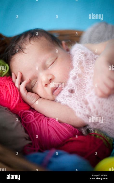 Cute Newborn Baby Girl Sleeping With Ball Of Wools In Basket