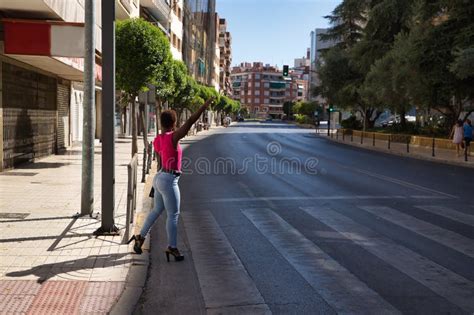 Mujer Afroamericana Con Una Camiseta Rosa Y Un Brazo De Jeans Levantados Al Costado De La