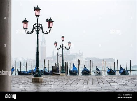 Romantic Promenade In Venice With Street Lamps And Blue Gondolas Docked