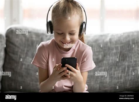 Happy Little Kid Girl Wearing Wireless Headphones Listen Music Stock