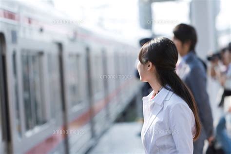 駅のホームで電車を待つ女性 28174009910 の写真素材・イラスト素材｜アマナイメージズ