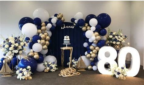 Balloons And Flowers Decorate The Entrance To An 80th Birthday Party