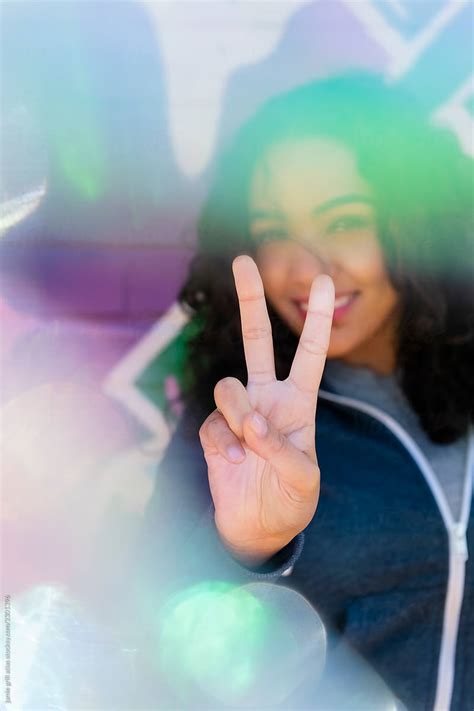 woman giving peace sign on city street by stocksy contributor jamie grill atlas stocksy