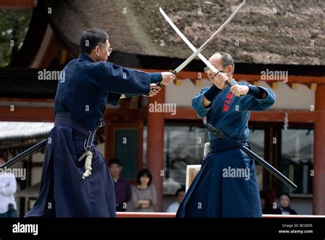 Two Men Engaged In A Sword Fight Using Real Samurai Swords During A
