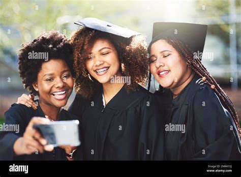 Squad goals. three students taking a selfie on graduation day Stock