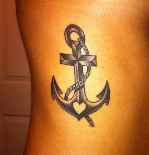 An Anchor Tattoo On The Back Of A Woman S Lower Body With A Cross And