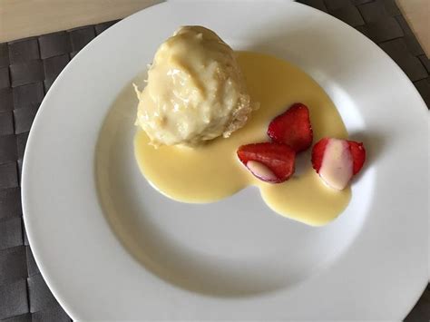 A White Plate Topped With Ice Cream And Strawberries