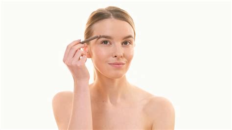 The Beautiful Woman Applying Makeup On Her Face On The White Background
