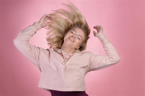 Happy Dancing Blonde In A Pink Hoodie On A Pink Background Photo In