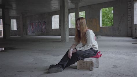 Sad Girl Sitting In A Big Dusty Empty Room In The Abandoned Building