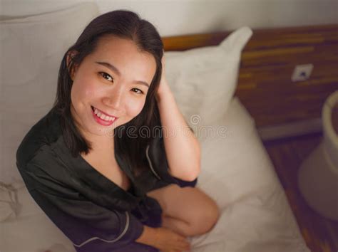 Young Beautiful And Sweet Asian Korean Woman In Bed Feeling Happy And Relaxed Wearing Cute