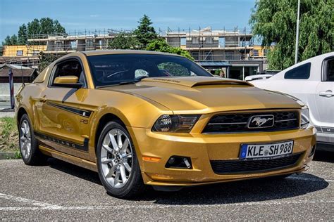 A Gold Mustang Parked In A Parking Lot