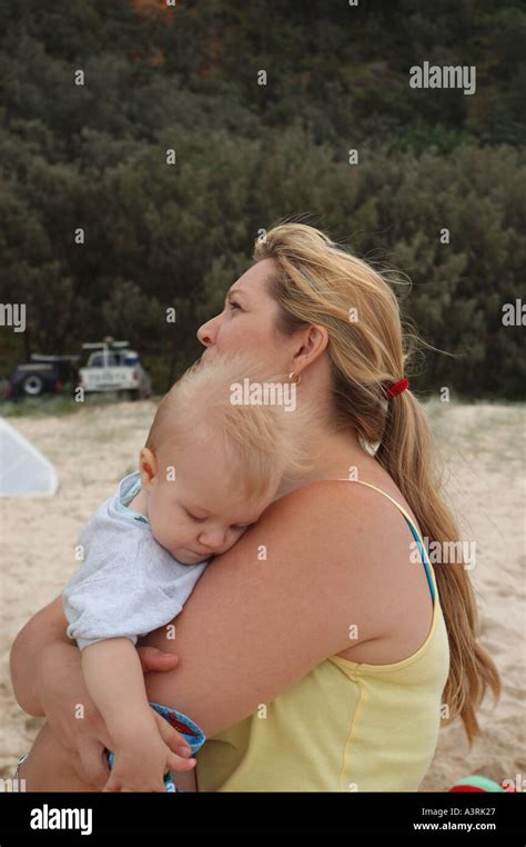 Blond Mother And Son Cuddle On Beach Queensland Australia Stock Photo