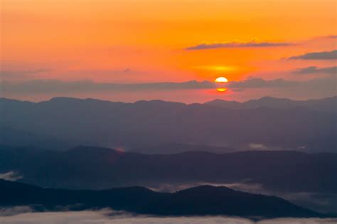 Puesta De Sol Con Vistas A Las Montañas Con Niebla Foto Premium