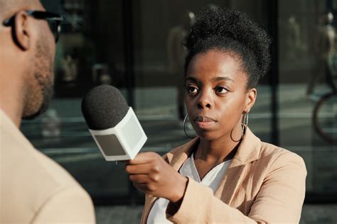 African Female Journalist Holding Microphone And Interviewing The Man