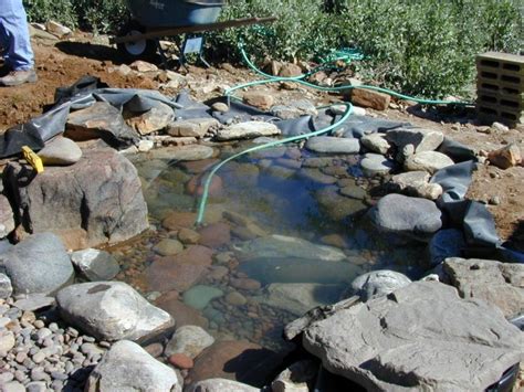 Lighted pond with crystal waterfalls on a brick wall. How to Create a Pond and Stream for an Outdoor Waterfall ...