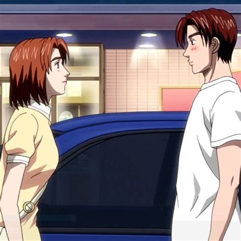 Two People Standing Next To Each Other In Front Of A Car