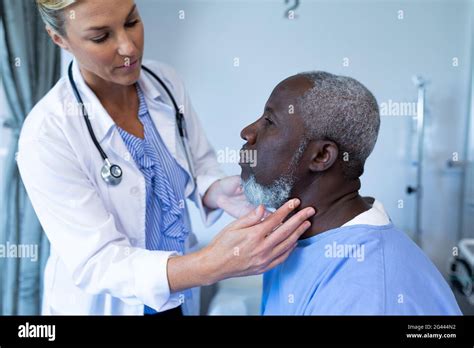 Caucasian Female Doctor Palpating Lymph Nodes Of African American Male
