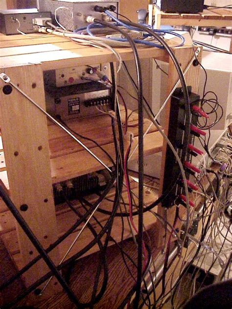 Many Wires Are Tangled Up And Connected To An Electronic Device In A Room With Wood Flooring