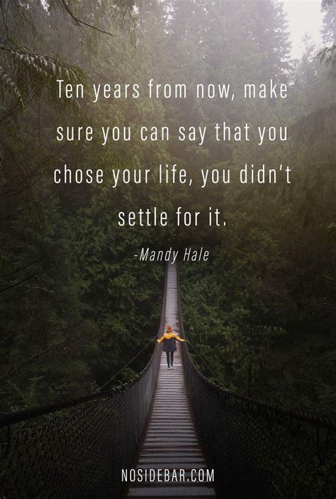 A Person Walking Across A Suspension Bridge In The Woods With A Quote