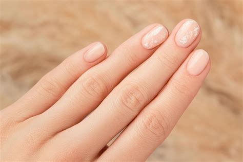 Premium Photo Beautiful Womans Hand With Nude Nail Design On Beige