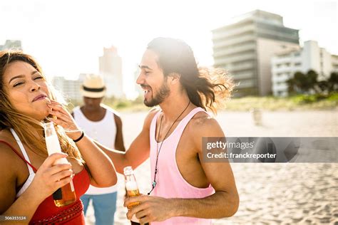 Group Of People Cheering Beers At Dusk On The Beach High Res Stock