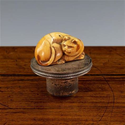 19th century netsuke fat cat eating hand carved tagua nut 5x3x3cm signed. A Japanese carved ivory netsuke of a cat Edo period, the rec