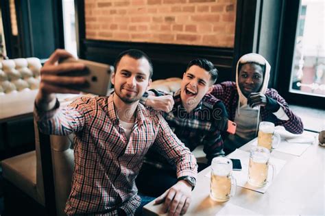 Multiracial Friends Group In Casual Clothes Are Smiling Taking Selfie